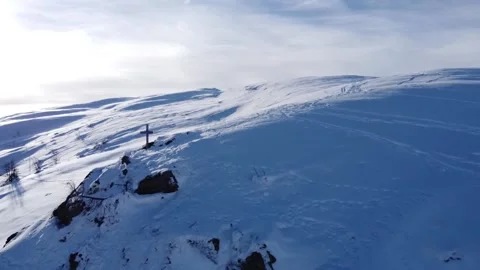 Drone flies past summit cross on snowy mountain peak Stock Footage 145803723