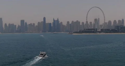 A drone flies by a private boat sailing on a calm sea towards the city Stock Footage 252871731