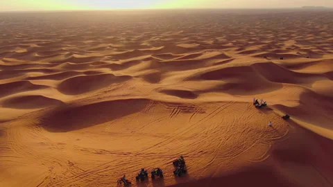 The drone flies to the quadra in cycles standing on sand dunes in the desert of Stock Footage 262301357