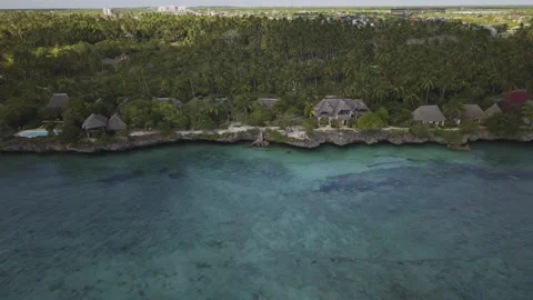 Drone flies to right along coastal seaside resort and Dimbani Beach Stock-Footage 346481613