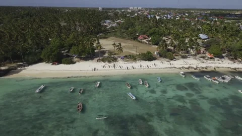 Drone flies right facng Dimbani Beach at high tide and then orbits around Stock-Footage 346481134