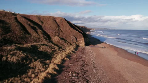 Drone flies sideways over beach and cliffs in County Durham Stock Footage 234187838