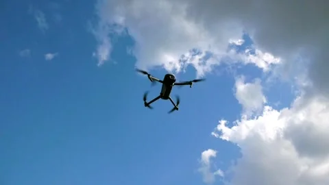 The drone flies in the sky against the background of clouds. The drone is Stock Footage 252501466