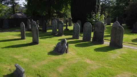 Drone flies slowly forwards through English graveyard Stock Footage 242162926