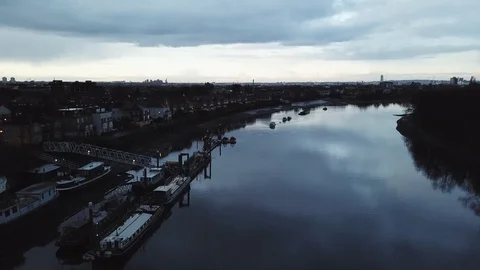 Drone flies slowly past river boats docked at a local marina in London, UK. Stock Footage 87848430