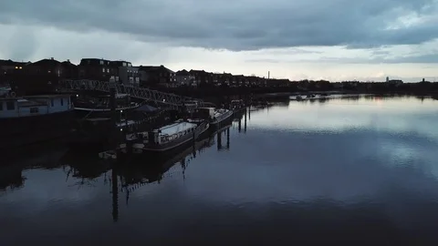 Drone flies slowly past river boats docked at a local marina in London, UK. Видео 87848617