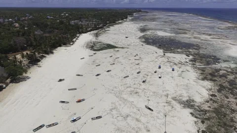 Drone flies south high over dhows at low tide on a sunny morning Stock-Footage 346078224