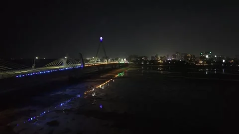 Drone flies south over low tide bay at night next to Tanzanite Bridge Video stock 342256336