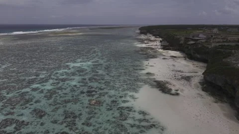 Drone flies south over tide pools and beach on a sunny morning Stock Footage 344057118