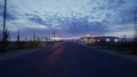A drone flies straight over a long and empty road in the middle of the desert Stock Footage 183392704
