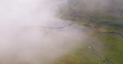 Drone flies through the cloud to reveal epic green landscape near the famous Stock Footage 288250312