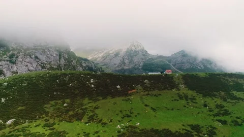 The drone flies through the hill and opens a mountain lake that reflects a rock. Stock Footage 150069718