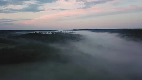 Drone flies through low rain clouds moving over fall colors treetops of woodland Stock Footage 145714841