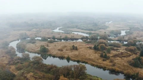 Drone flies through rain clouds moving over winding river in autumn forest Stock Footage 141007922