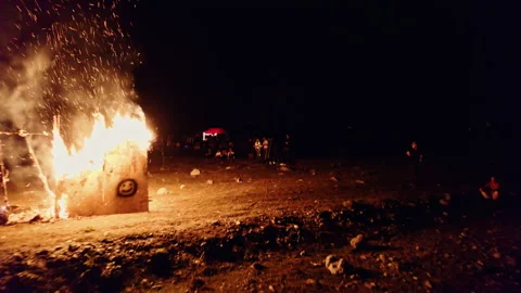 Drone flies through sparks of a fire and people watching fire outside Stock Footage 253975680