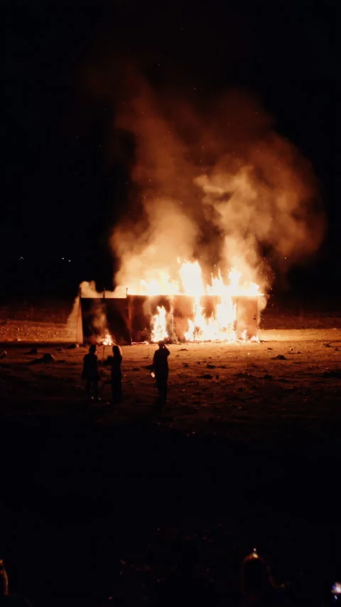 Drone flies through sparks of a fire and people watching Stock Footage 253999504