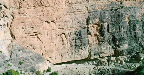 Drone flies through stone wall and hiker woman walks under stone Stock Footage 146964810