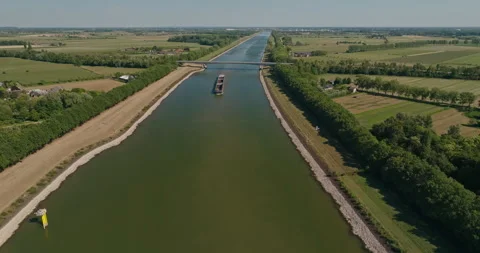 Drone Flies Toward Barge on River Through Dutch Green Polder Landscape Stock Footage 344463093
