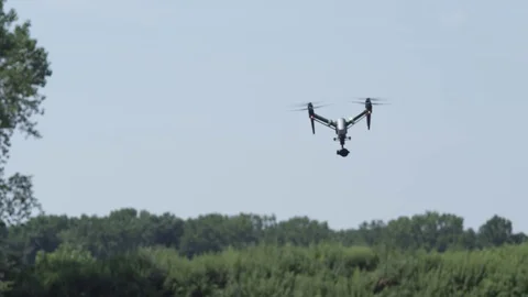 Drone flies towards and over camera in front of trees Stock Footage 80151856