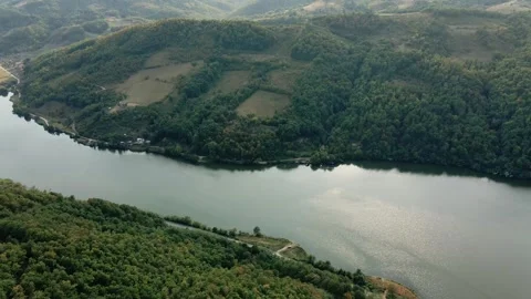 Drone flies towards river Danube surrounded with green wooded hills Stock Footage 263144863