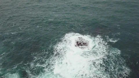 A drone flies towards the rough ocean showing the green and blue of the sea 動画素材 246918331