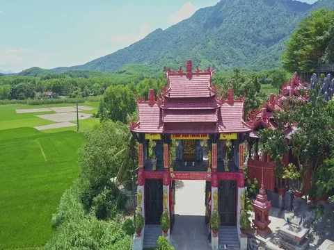 Drone Flies under Temple Entrance Shows Courtyard among Plants Stock Footage