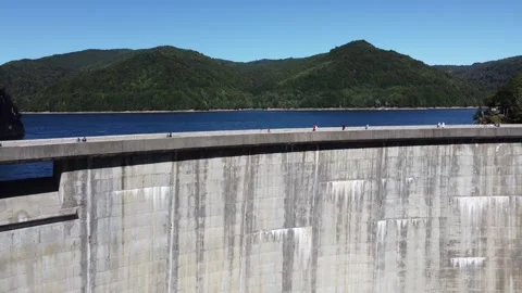 Drone flies vertically over Vidraru dam in Romania on a sunny summer day Stock Footage 312702783