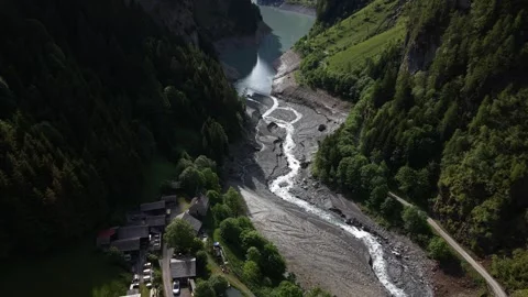 Drone Flight Above Alpine River Revealing Reservoir Hidden Between Mountains Video stock 336366914
