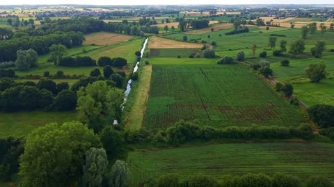 Drone flight above irrigation canal, maize fields and farmland in rural France Stock Footage 339111592