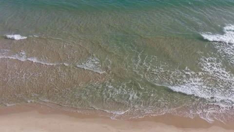 Drone flight above quiet beach with surf and sand Stock Footage 328571908