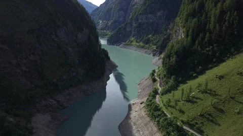 Drone Flight Above Turquoise Alpine Reservoir and Scenic Mountain Road Stock Footage 336368218