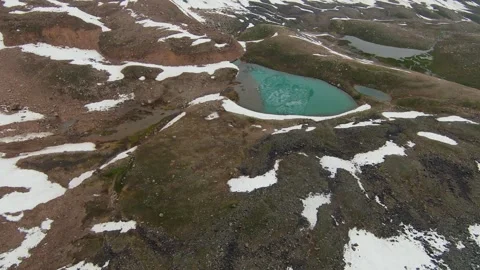 Drone flight above a turquoise alpine lake in the mountains of Kazakhstan Stock Footage 340423110