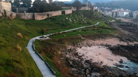 Drone flight above the walking path of the Baiona Parador Castle in Galicia, Stock Footage 122467884