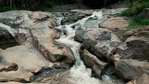 Drone flight above a wild cascade winding through green jungle Video stock 343408067