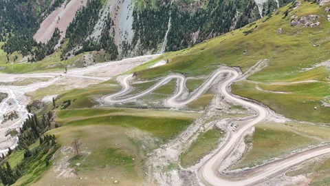 Drone flight above winding serpentine road in scenic mountain gorge. Stock Footage 315443340
