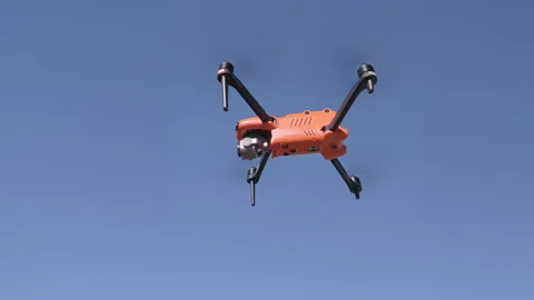 Drone in flight against clear blue sky,showcasing aerial capabilities and design Stock Footage 339042761