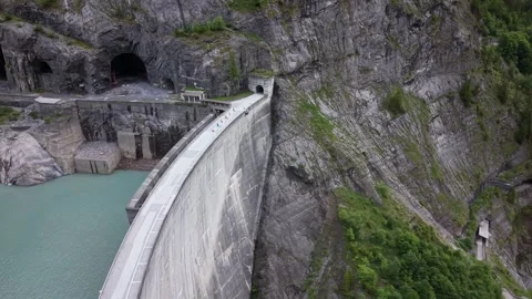 Drone Flight Along Massive Alpine Dam Toward Mountain Tunnel Stock Footage 336367796