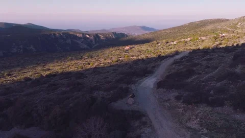 Drone Flight Along Mountain Dirt Road With Tent and Motorcycle Stock Footage 337770360