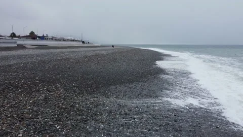 Drone flight along the ocean seashore ocean and waves on a cloudy day with snow Stock Footage 232970557