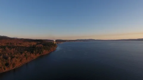 Drone flight along red pine forest and sea at sunset Video stock 126998572