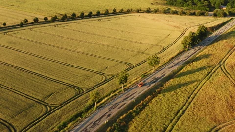 Drone flight along a road on which a red car is driving. Stock Footage 163092842