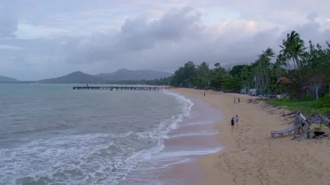 A drone flight along the sandy beach with people at Koh Samui island, stunning Stock Footage 273964649