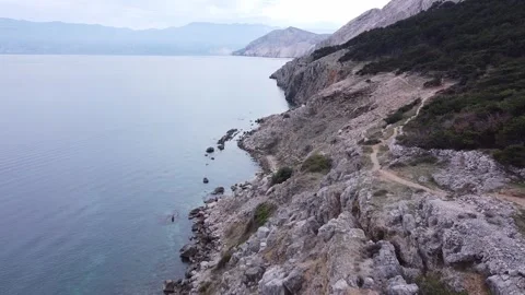 Drone flight along a steep cliff by the sea Video stock 262993950
