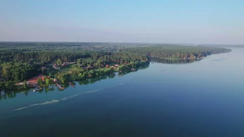 Drone flight around along lake and river bank with small houses and piers Stock Footage 219567735