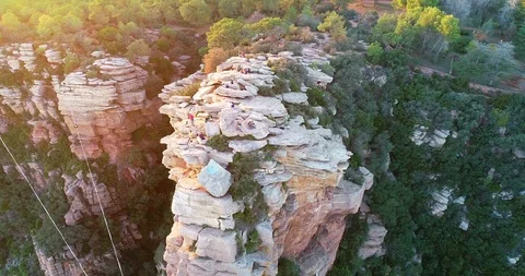 Drone flight around boulder peak with climbers hikers Stock Footage 124222899