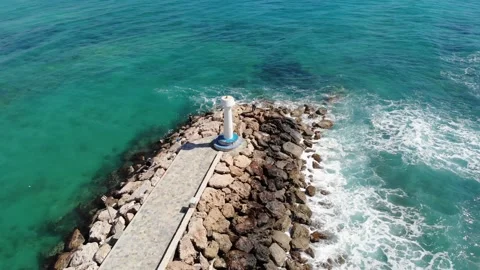 Drone flight around the lighthouse over the breakwater and the sea Stock Footage 161643406