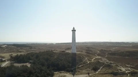 Drone flight around Lyngvig lighthouse on Denmarks North Sea coast in backlight Stock Footage 87254738