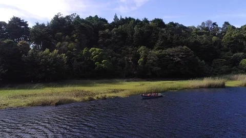 Drone flight around a volcanic lagoon and a group of tourist Stock Footage 100790626