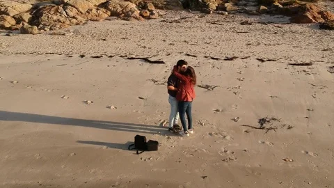 Drone flight around a young couple on a beach Stock Footage 123217160