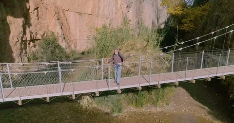 Drone flight back into deep river gorge and elderly person walking Stock Footage 124388183